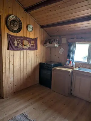 a kitchen with a stove and a sink in a cabin at Nordseter Sjusjøen fiske, jakt, tur og ski in Lillehammer