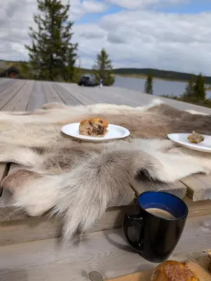 a table with plates of food and a cup of coffee at Nordseter Sjusjøen fiske, jakt, tur og ski in Lillehammer