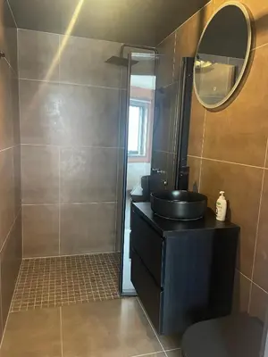a bathroom with a black sink and a mirror at Modern 4-Bedroom Apartment in Beitostøl
