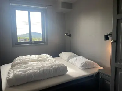 a bed with two pillows on it with a window at Modern 4-Bedroom Apartment in Beitostøl