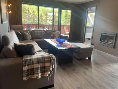 a living room with a couch and a table at Modern 4-Bedroom Apartment in Beitostøl