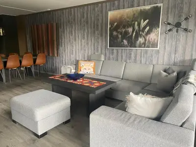 a living room with a couch and a table at Modern 4-Bedroom Apartment in Beitostøl