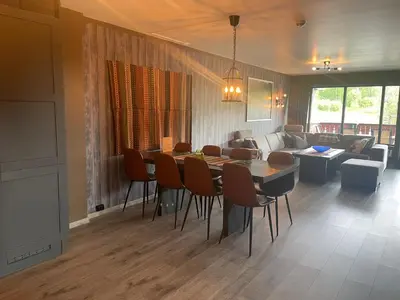 a living room with a table and chairs and a couch at Modern 4-Bedroom Apartment in Beitostøl