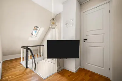 a flat screen tv hanging on a wall in a room at Charming Townhouse - Walk Everywhere! in Bergen