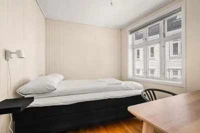 a bed in a room with a table and a window at Charming Townhouse - Walk Everywhere! in Bergen