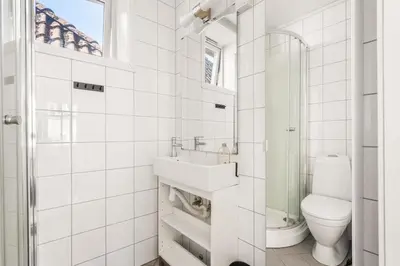 a white bathroom with a toilet and a sink at Charming Townhouse - Walk Everywhere! in Bergen