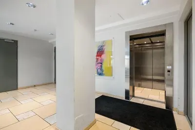 a hallway with white walls and a door with a rug at Central Bergen apt w Balcony in Bergen