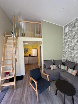 a living room with a couch and a stair case at Flåm Tinyhouse with a Waterfall View in Flåm