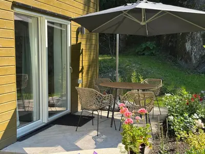 a patio with an umbrella and a table and chairs at Flåm Tinyhouse with a Waterfall View in Flåm