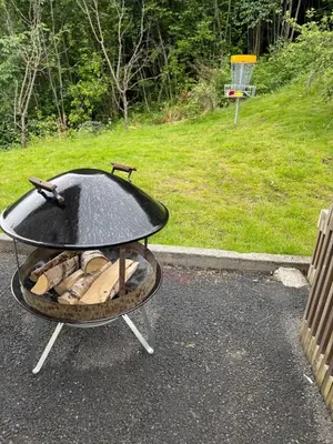 a fire pit with a grill in a yard at Nylendo in Ulvik
