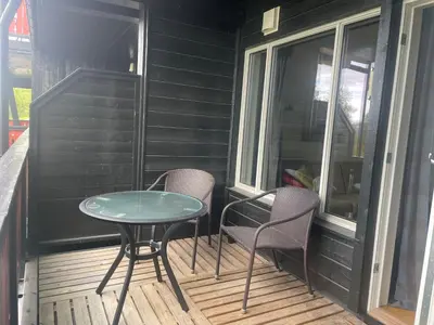 a table and two chairs on a screened porch at Sentral, Hc-Friendly Apartment in Beitostøl