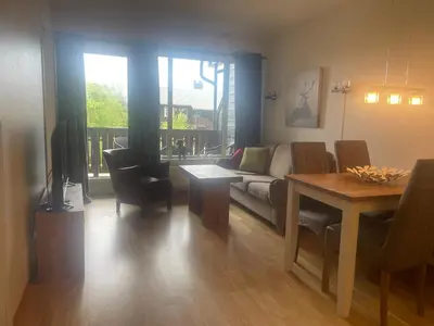 a living room with a couch and a table at Sentral, Hc-Friendly Apartment in Beitostøl