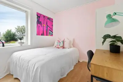 a bedroom with a white bed and a window at Townhouse with free parking in the city centre - 4 bedrooms in Ålesund