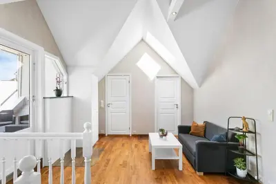 a living room with a couch and a table at Large apartment with 5 bedrooms, 2 bathrooms and roof terrace in Ålesund
