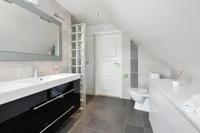 a bathroom with a sink and a toilet at Large apartment with 5 bedrooms, 2 bathrooms and roof terrace in Ålesund