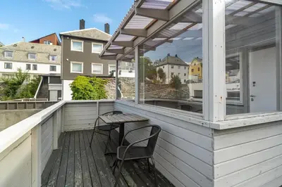 a patio with a table and chairs on a balcony at City apartment with 4 bedrooms & private terrace in Ålesund