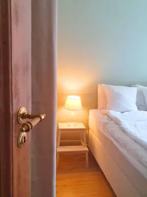 a bedroom with a bed and a lamp on a night stand at You cottage in the city in Bergen