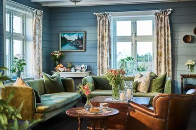 a living room with green couches and a table at Stangeland Gard in Austevoll