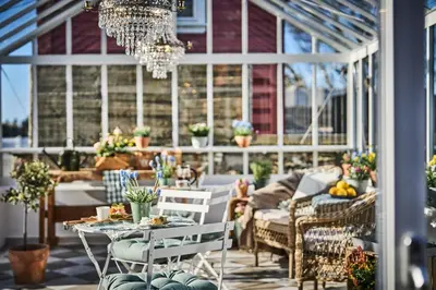 a conservatory with a table and chairs and a chandelier at Stangeland Gard in Austevoll
