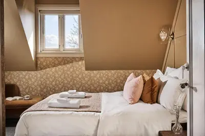 a bedroom with a bed with white sheets and pillows at Stangeland Gard in Austevoll