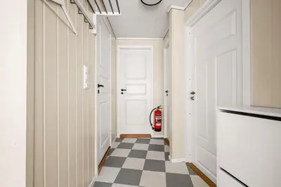 a hallway with a white door and a checkered floor at Bergen Charm - Right in the City Center! in Bergen
