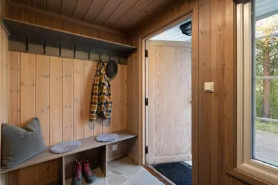 a wooden cabin with a bench and a window at 4-Bedroom Ski-In Family Cabin at Geilolia hyttetun in Hol