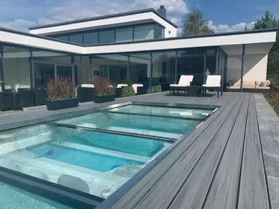 a swimming pool in front of a house at Exclusive seafront villa in Ålesund