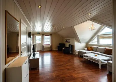 a living room with a couch and a table at Seljevaagen Penthouse in Selje