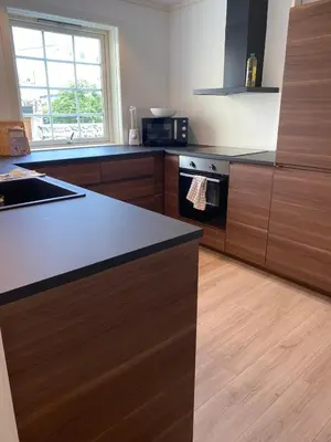 a kitchen with wooden cabinets and black counter tops at 4 bedroom apartment in Ålesund City in Ålesund