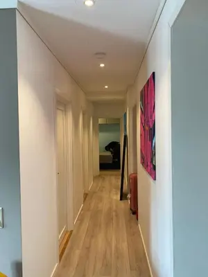 a hallway with white walls and wood floors at 4 bedroom apartment in Ålesund City in Ålesund