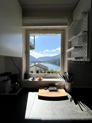 a kitchen with a large window with a view at Fjord view apartment in Vaksdal