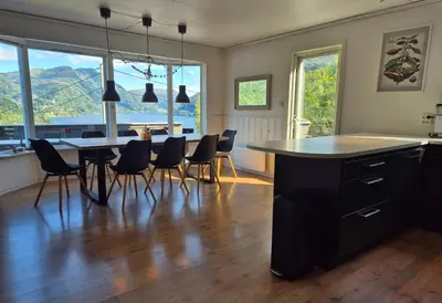 a kitchen and dining room with a table and chairs at Bluewater Cottage - Blåvannshytta in Bergen