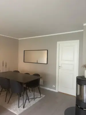 a dining room with a table and chairs and a white door at Cozy apartment at Laksevåg! in Bergen