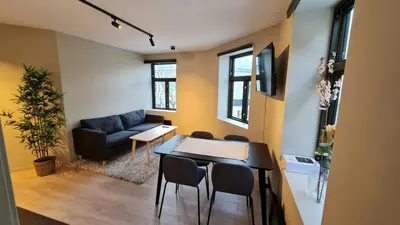 a living room with a couch and a table and chairs at Central and Spacious Apartment for 6 in Trondheim