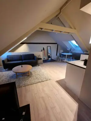 a living room with a blue couch and a table at Central Studio for 2 in Trondheim