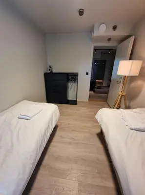 two beds in a room with a flat screen tv at Central Apartment for 4 in Trondheim