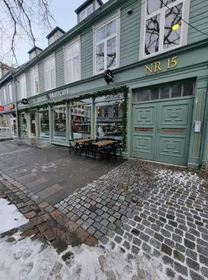 a green store front with a bench in front of it at Central Apartment for 2 in Trondheim