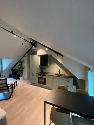 a kitchen and living room with a table and chairs at Central Apartment for 5 in Trondheim