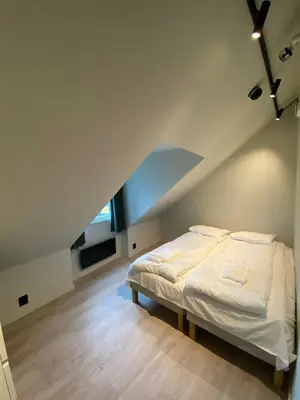 a bedroom with a white bed in a attic at Central Apartment for 5 in Trondheim