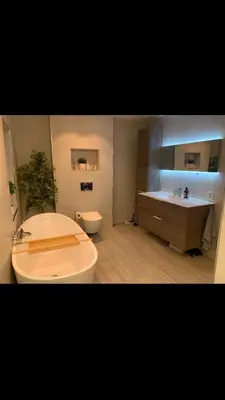 a bathroom with a tub and a toilet and a sink at Duplex near airport in Bergen
