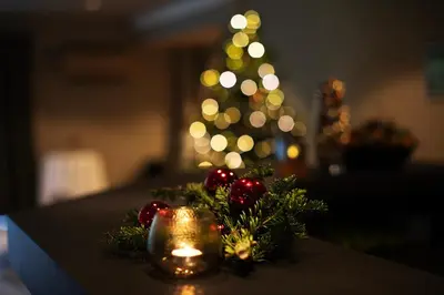 a table with a candle and christmas decorations with a christmas tree at Elvehagen Hotell in Sande