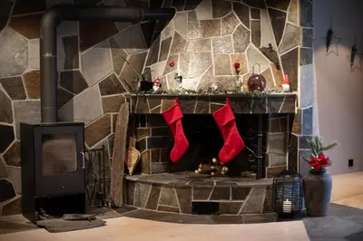 a fireplace with red christmas stockings on it at Elvehagen Hotell in Sande