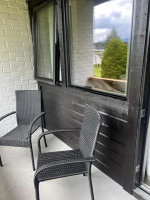 two chairs sitting on a porch looking out a window at Elvehagen Hotell in Sande