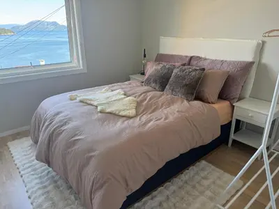 a bedroom with a bed with a window at Koselig leilighet med utsikt, gåavstand fra sentrum in Stord