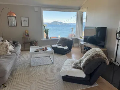 a living room with a view of the ocean at Koselig leilighet med utsikt, gåavstand fra sentrum in Stord