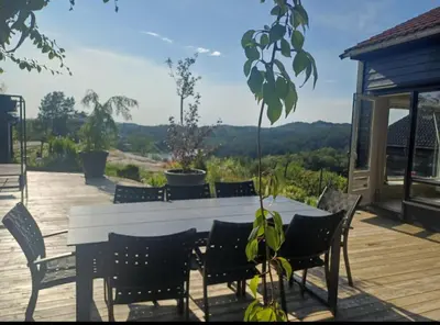 a table and chairs on a deck with a view at Villa Varden 10 min from Bergen sentrum in Bergen