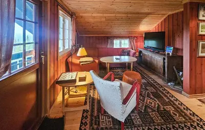 a living room with a couch and a table and a television at Amazing Home In Eggedal With Sauna in Eggedal