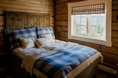 a bed in a log cabin with a window at Tømmerhytte Med Utsikt Over Jotunheimen in Gålå
