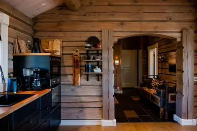a kitchen with wooden walls and an archway at Tømmerhytte Med Utsikt Over Jotunheimen in Gålå
