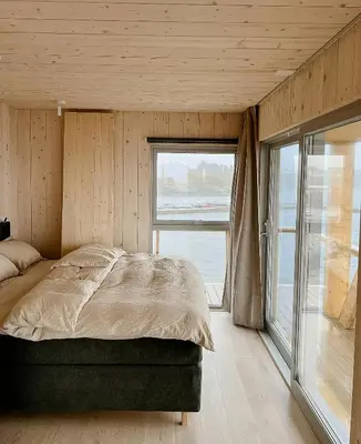 a bedroom with a bed and a large window at Architectural Gem On Rocks In Kvenvær in Kvenvær